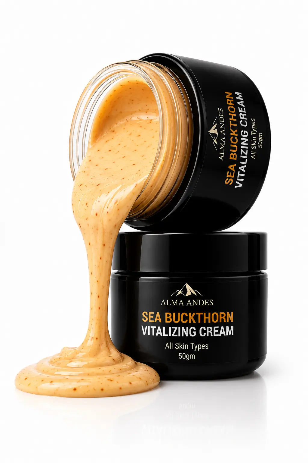 Alma Andes Sea Buckthorn Vitalizing Cream in a black jar, with one jar tipped over to show the thick, glossy, orange-beige cream dripping out onto a white surface.