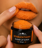 A close-up of a person holding an open jar of Seabuckthorn Sugar Lip Scrub, with orange scrub visible in the jar and on their lips.