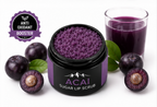 Acai sugar lip scrub with a glass of acai juice and acai berries on a white background.