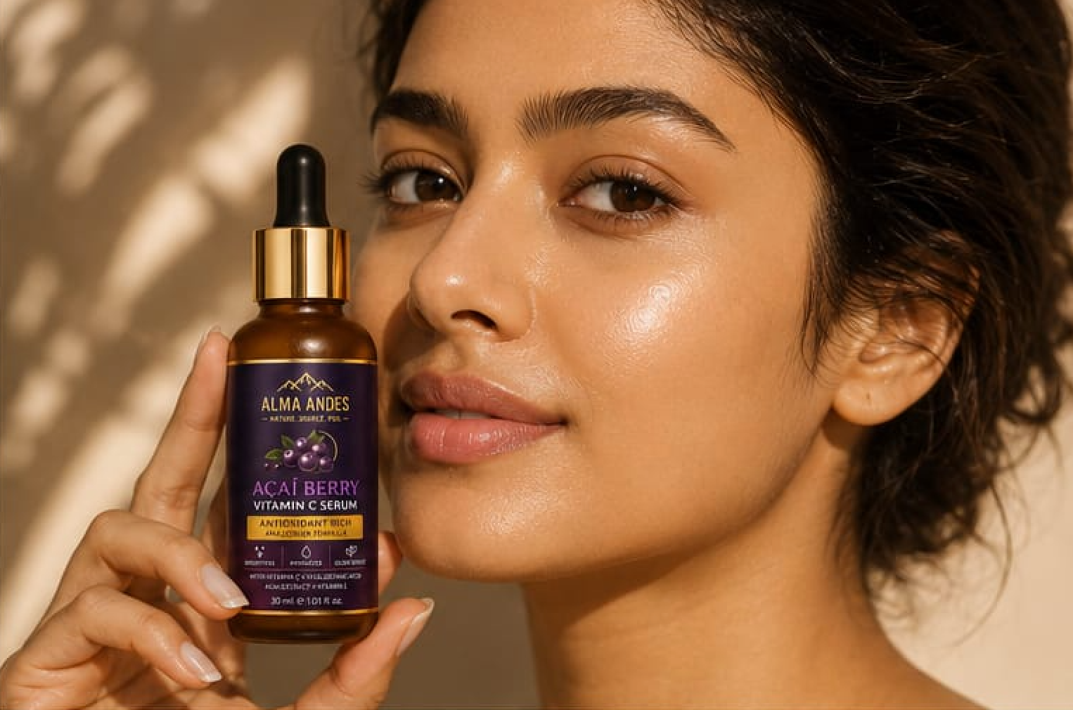 Woman holding a bottle of Alma Andes Acai Berry Vitamin C Serum against a neutral background