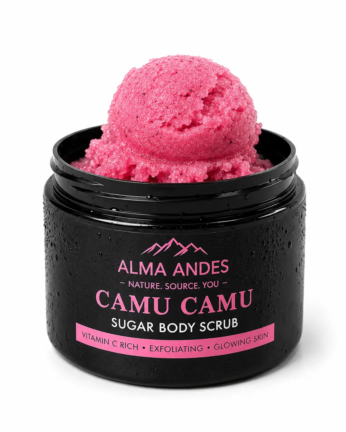 A black jar of Alma Andes Camu Camu Sugar Body Scrub, shown open with a scoop of bright pink scrub on top, against a white background.