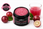 Camu camu sugar lip scrub with ingredients and a glass of juice on a white background