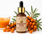 Seabuckthorn De-Tan Glow Serum bottle with sea buckthorn berries and a glass of juice on a white background