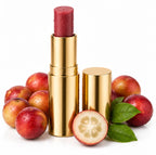 Gold lipstick with red lipstick next to plums and a halved plum on a white background