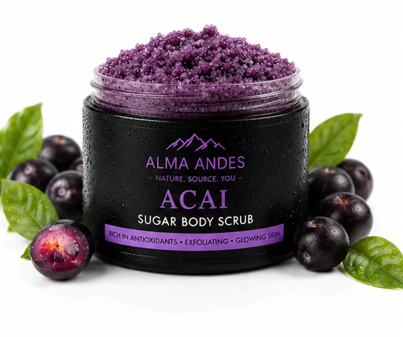 Acai sugar body scrub in a black jar with acai berries and leaves on a white background